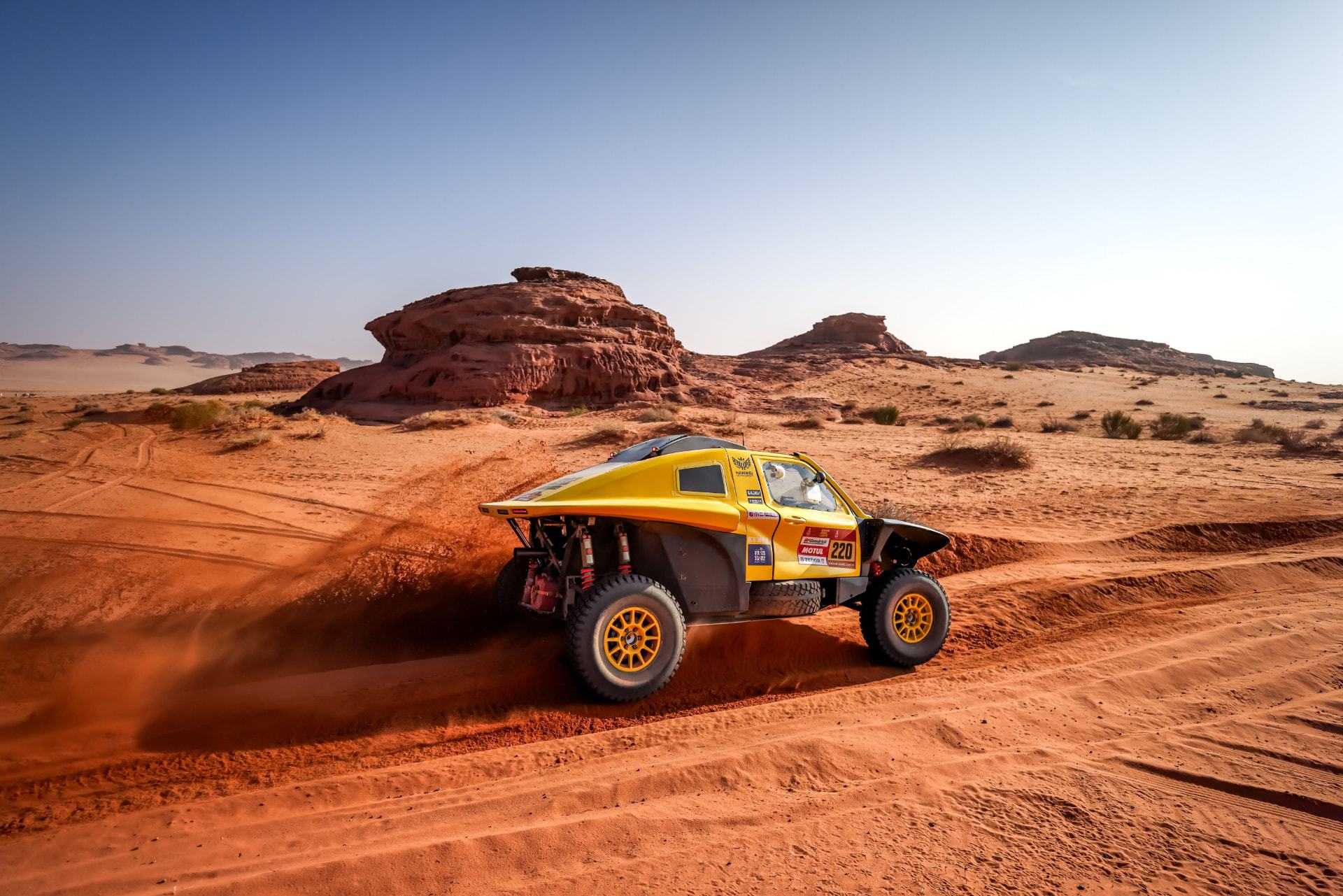 HWM T1+ race car number 220 on red desert sand with sandstone formations